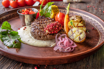 Filet mignon steak served with grilled vegetables, mushrooms and cheese sauce, restaurant dish,...