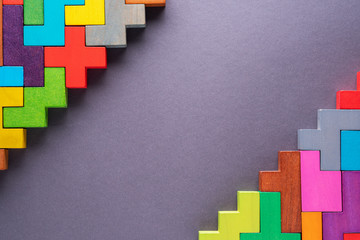 Different colorful shapes wooden blocks on gray background.