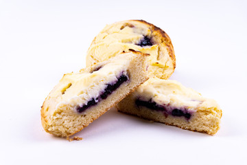 A cut cookie cheesecake with blueberries on white background with copy space - angled view