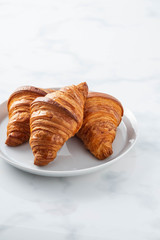 plate of freshly baked croissants isolated on white background
