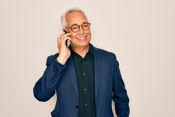 Middle age senior grey-haired business man wearing glasses talking on smartphone with a happy face standing and smiling with a confident smile showing teeth