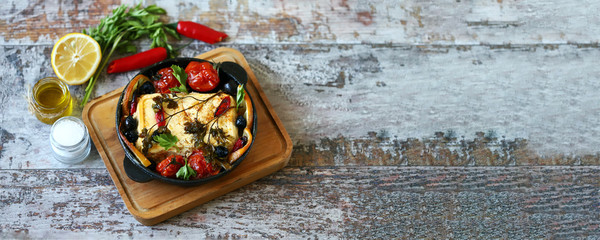 Selective focus. A pan with baked feta, spices and vegetables. Keto diet. Baked feta cheese....