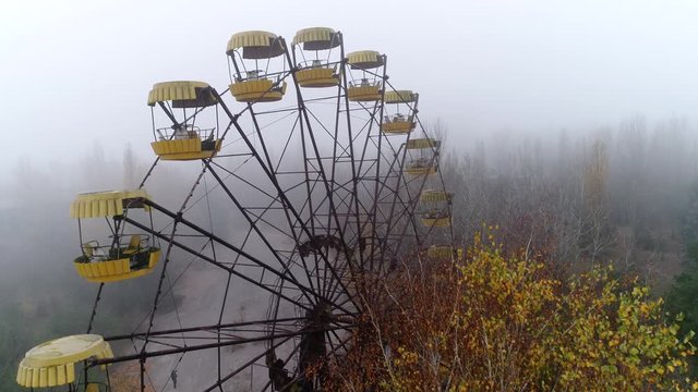 Video from a drone in an abandoned city of Pripyat in the Chernobyl exclusion zone. Ferris wheel in the fog. Amusement park