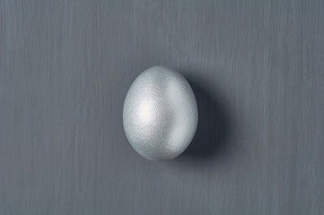 Silver egg on dark concrete background. Concept of easter, pricelless ideas, successful business...