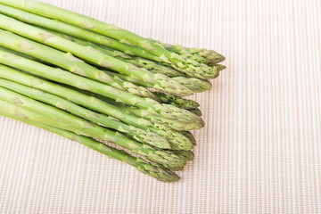 Bunches of asparagus tied on a burlap background.