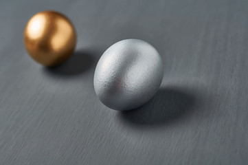 Golden and silver eggs on dark concrete background. Concept of easter, pricelless ideas, successful business investment or luxury breakfast