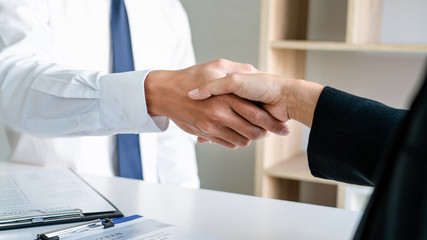 businessman and businesswoman handshaking over the office desk after Greeting new colleague,...