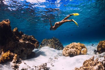 Woman freediver swimming over with yellow fins in ocean. Freediving or snorkeling in Mauritius