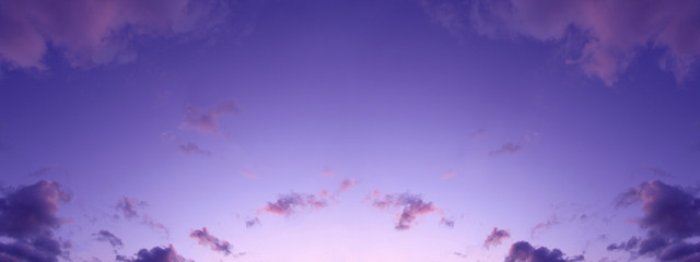 Beautiful background of the evening sky with clouds. Evening clear sky with small fluffy clouds. A banner with a gently purple pink sunset.