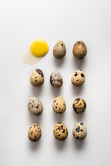 Several quail eggs lie on a light background. Broken egg. Pattern. Easter background