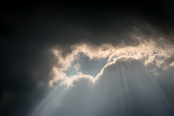 An unusual cloud formation with dark storm clouds meeting light, a bright silver lining as the sun...