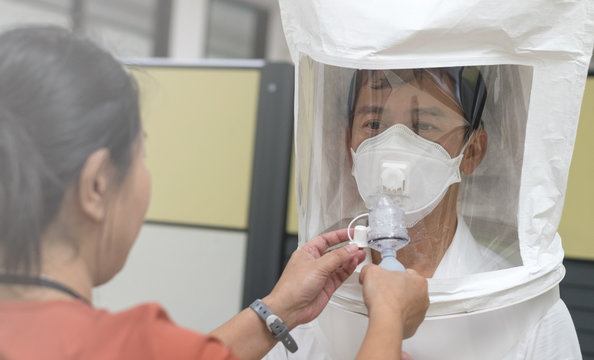 Respirator fit test prepared for COVID-19. Asia man testing repiratory system with N-95 surgical mask to checks properly fits face to wears.