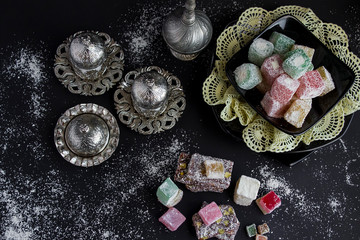 Traditional Turkish sparkling coffee and Turkish Delight designed on the black surface.