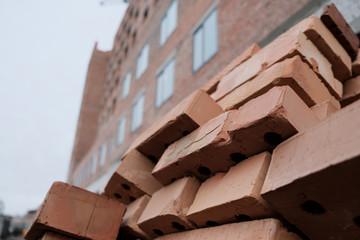 Set of red bricks used in construction site and home building background