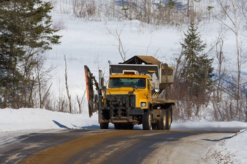 Camion de déneigement sur un chemin forestier au Québec, Canada
