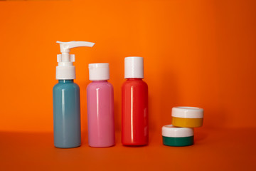 Set of travel bottles in a orange background.