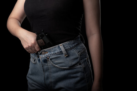 Woman one hand holding pistol gun at the black background, Young sexy girl with carrying a handgun, Pretty women stand with a guns