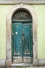 Fototapeta premium Old and colorful green wooden door with iron details