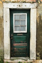Old and colorful green wooden door with iron details