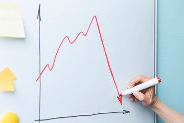 Hand draw down arrow. The concept of a falling economy, crisis.