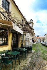 Empty bar terrace on Narrow street of Lisbon in a cloudy day