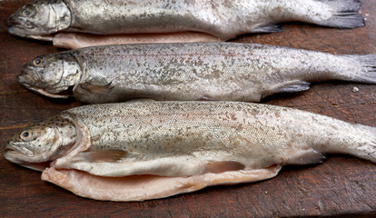 fresh peeled trout fish on a brown cutting board