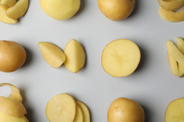 Flat lay with young potato on grey background, top view