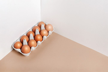 A dozen eggs in a box on the table, front view. Minimalistic product concept.