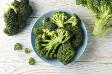 Plate with broccoli on wooden background, top view. Healthy food