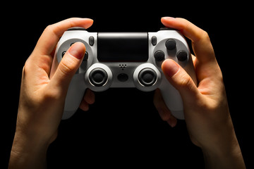 Hyman hands holding white video game gamepad isolated on a black background