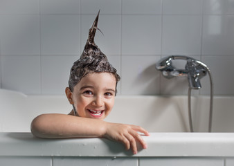 Funny portrait of smiling child in the bathtub 