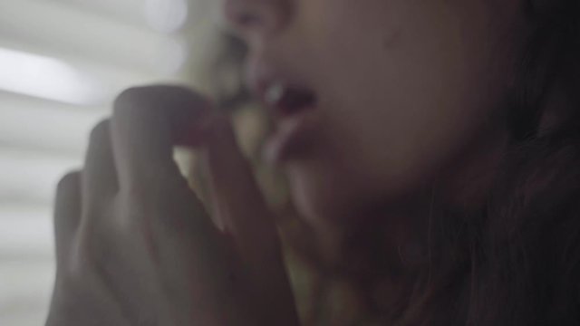 Young woman indoors takes a pill and swallow with a glass
