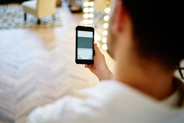 Unrecognizable male texting on cellphone