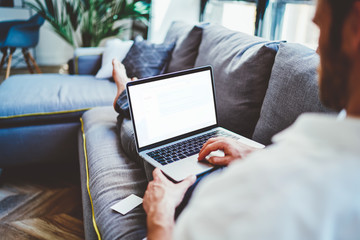 Unrecognizable businessman working on laptop at home