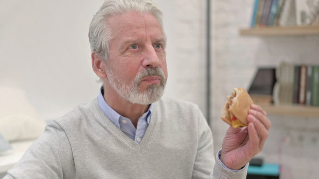 Hungry Senior Old Man Eating Cheese Burger