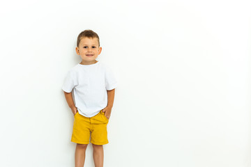 Cute little boy in yellow shorts and white t-shirt