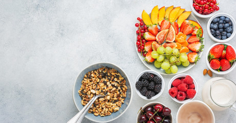 Raw vegan nut paleo style granola or muesli. Fruit berries platter, strawberries blueberries raspberries peach figs red currant, overhead view, banner, copy space for text, selective focus