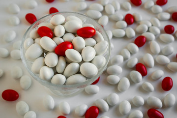 Red-white almond candies in glacc bowl at  white background with many.Top view.The Sugar Feast after Ramadan