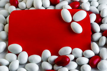 The Sugar Feast celebration blank card on white surface with red-white almond candies.