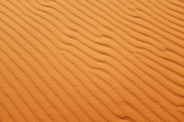 Bright orange desert sand ripples for hot summer background.