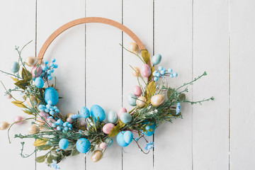 Easter Eggs Spring Background. Easter wreath on wooden white background