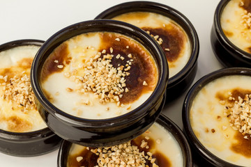 Traditional Turkish Style Baked Rice Pudding in casserole,clay dessert bowls,on white surface,close up