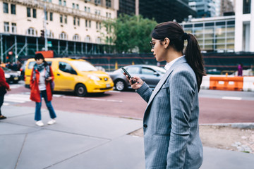 Businesswoman talking on phone while walking in downtown