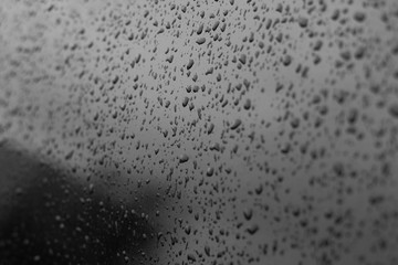 Drops of water on a car glass. Black tinted car window with raindrops. Texture for design.