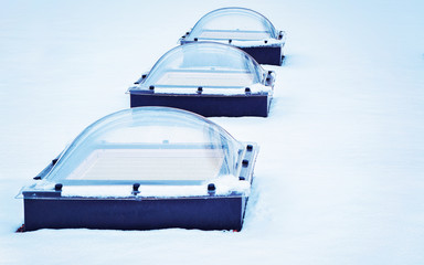 Skylight glass domes on roof of building in snow Helsinki