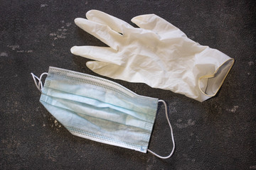 Medical mask and rubber gloves on a black background. Virus and Flu Control