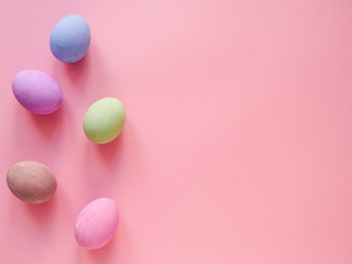 Flat lay composition of Happy Easter holiday concept. Colorful pastel egg on pink background. Copyspace, top view.