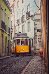 Naklejka na ściany i meble Old vintage tram in a narrow street of Lisbon, Portugal