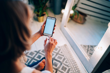 Woman surfing cellphone sitting in room