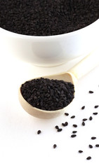 black seeds with a wooden spoon